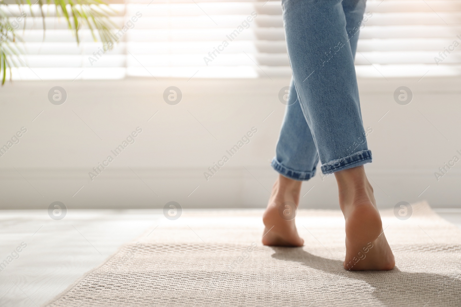 Photo of Woman standing on carpet at home, closeup. Space for text