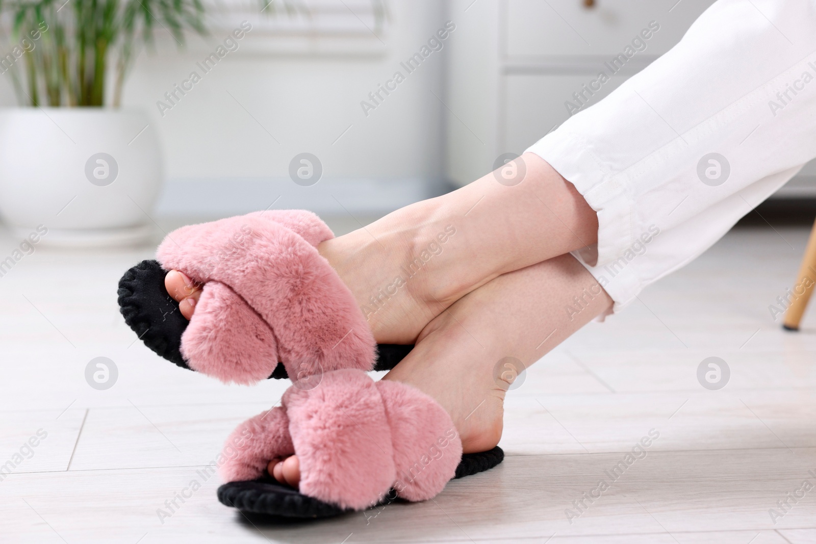 Photo of Woman in soft slippers at home, closeup