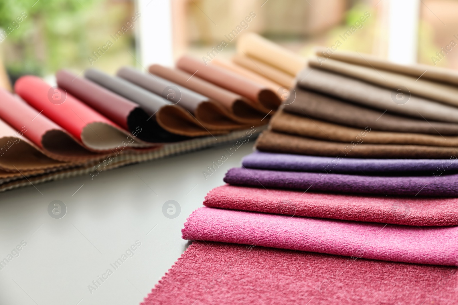 Photo of Fabric and leather samples of different colors for interior design on table