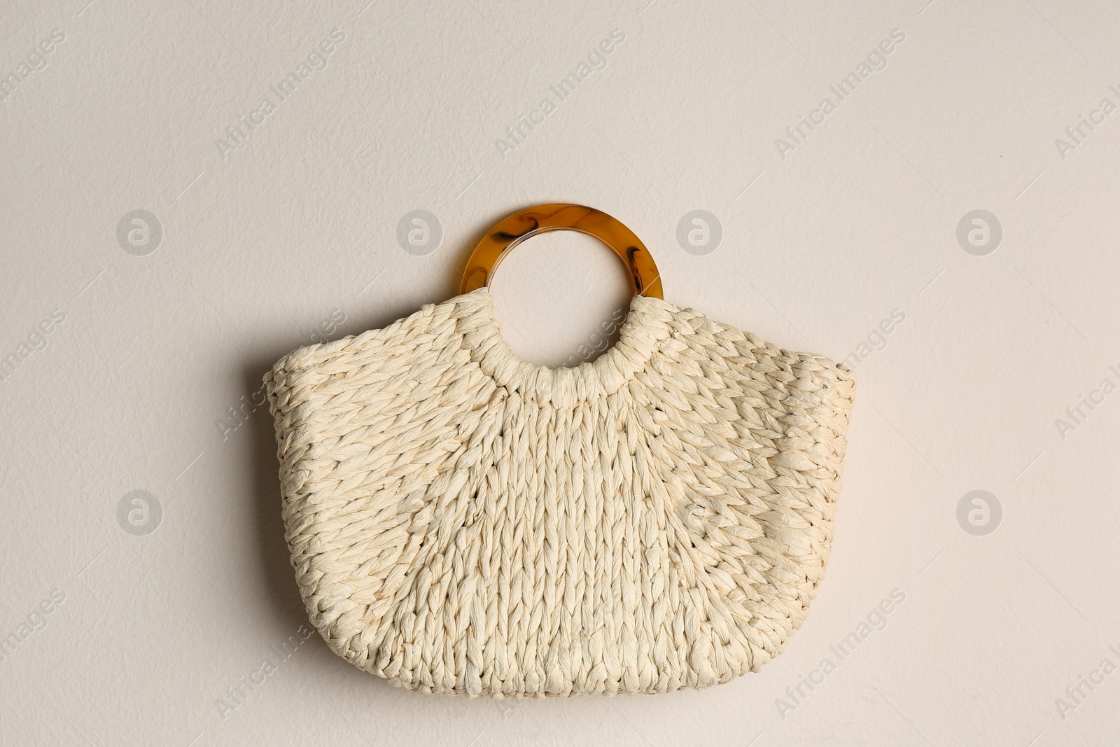 Photo of Elegant woman's straw bag on beige background, top view