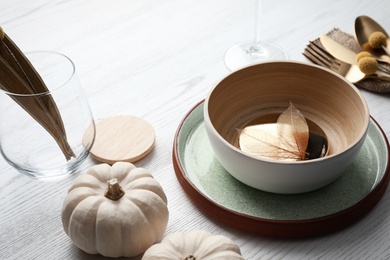 Photo of Autumn table setting with pumpkins on white wooden background