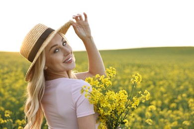 Portrait of happy young woman in field on spring day