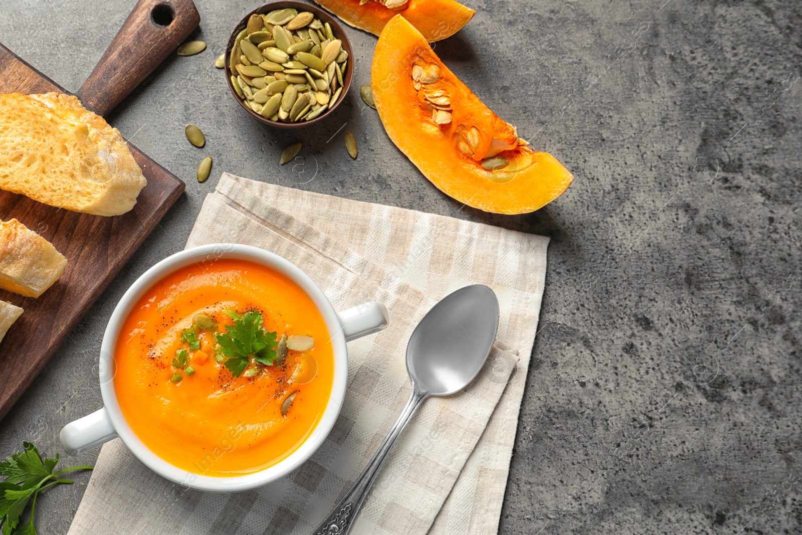 Photo of Flat lay composition with bowl of pumpkin soup on table. Space for text