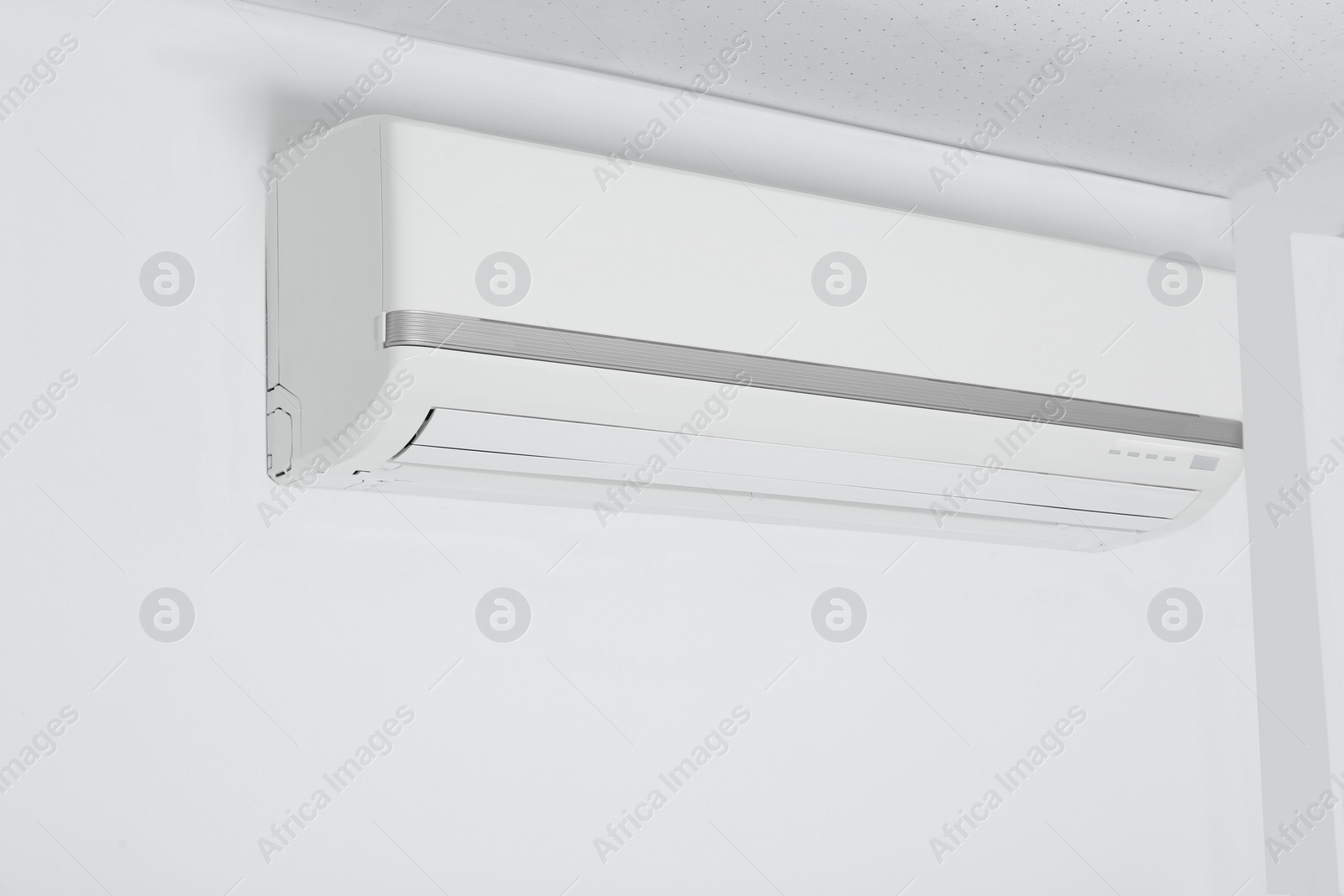 Photo of Modern air conditioner hanging on white wall