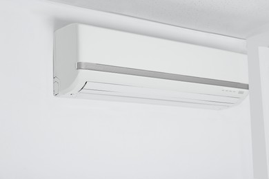 Modern air conditioner hanging on white wall