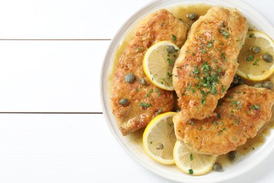 Photo of Delicious chicken piccata on white wooden table, top view. Space for text