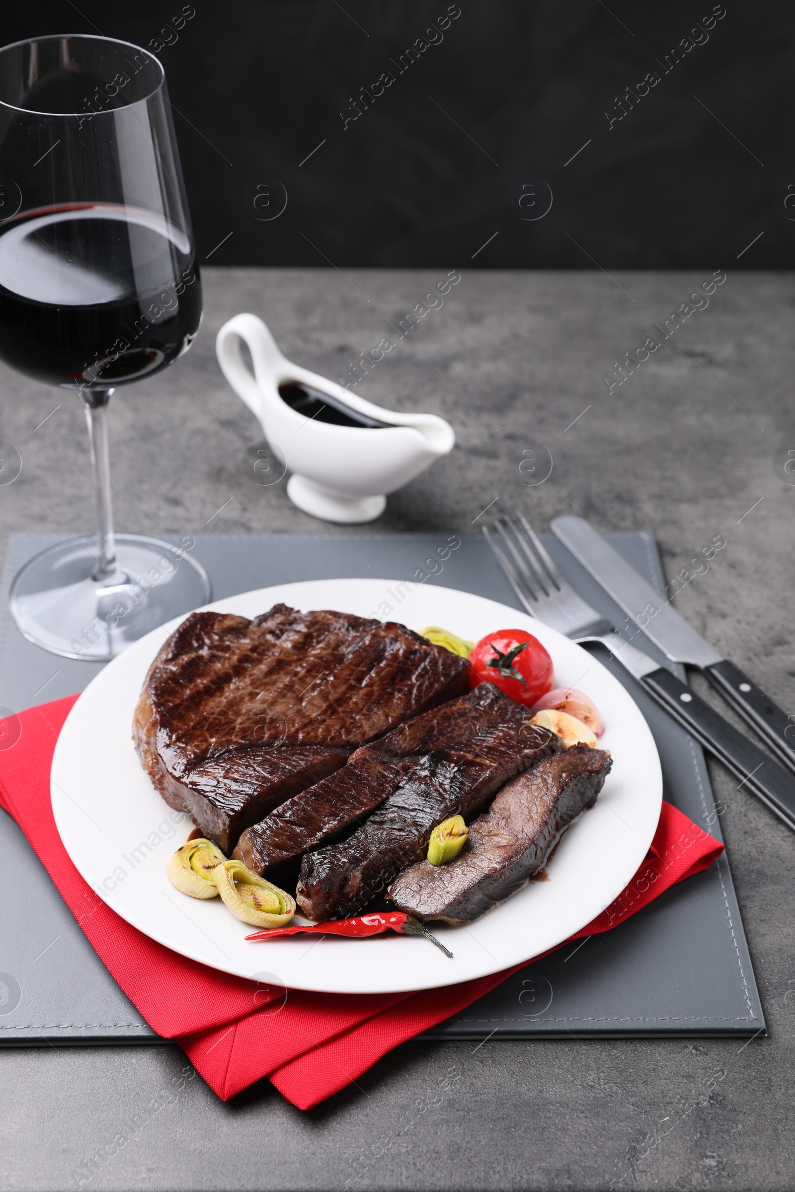 Photo of Delicious grilled beef meat served on grey table