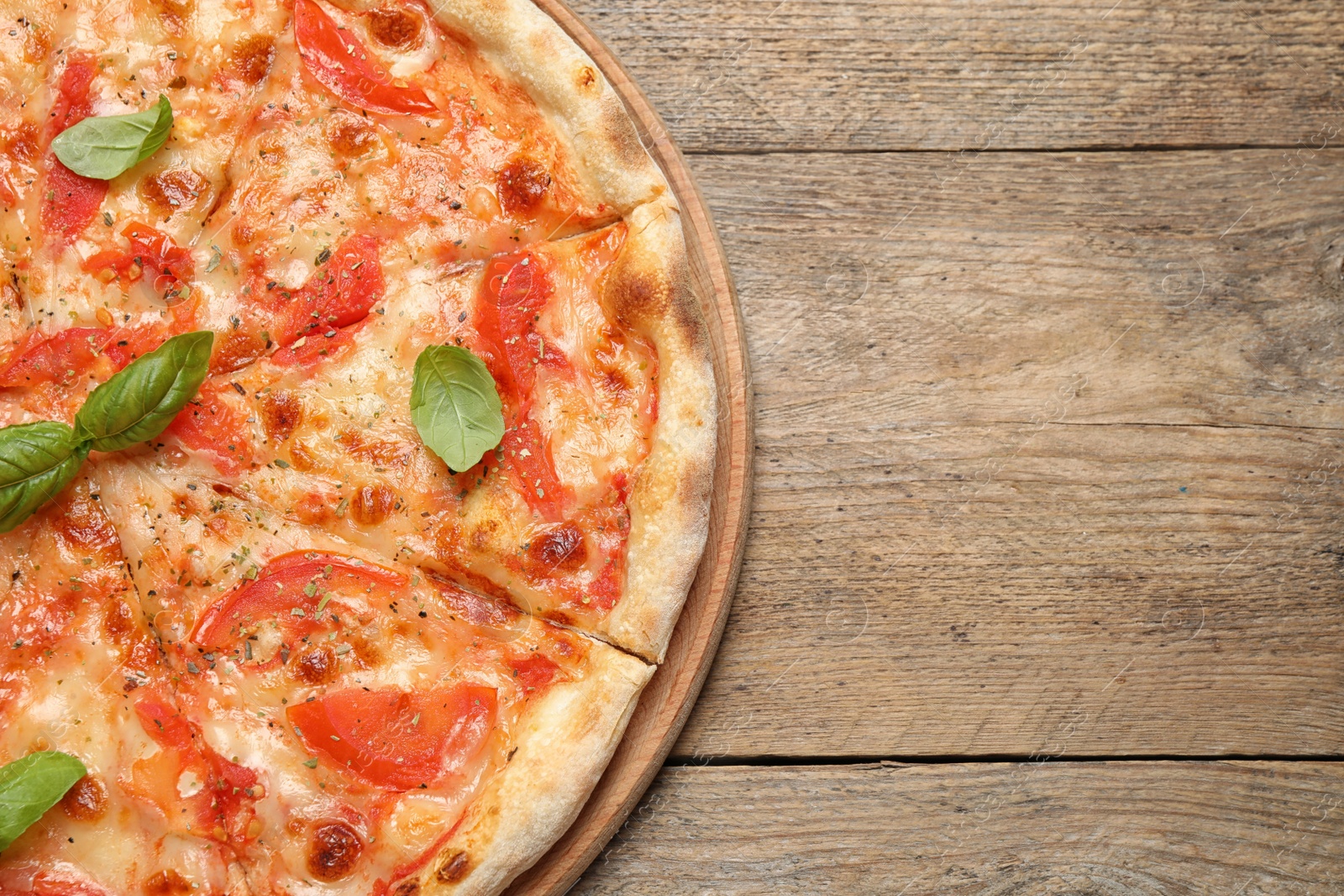 Photo of Delicious pizza Margherita on wooden table, top view. Space for text