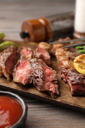 Delicious grilled beef steak on wooden table, closeup