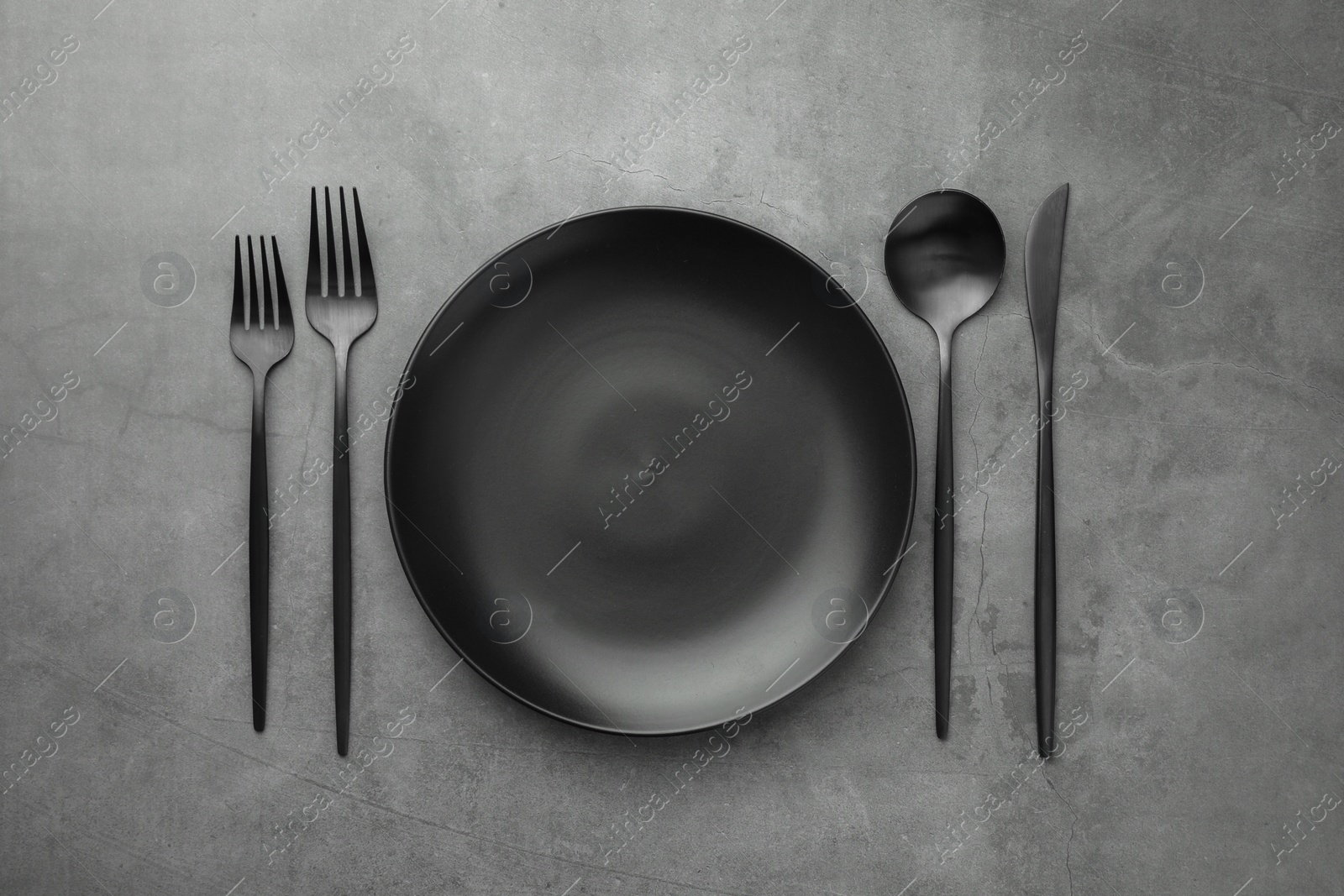 Photo of Empty plate and cutlery on grey table, flat lay