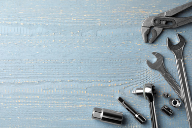 Modern auto mechanic's tools on grey wooden table, flat lay. Space for text