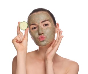 Photo of Beautiful woman with clay mask holding piece of cucumber and blowing kiss on white background