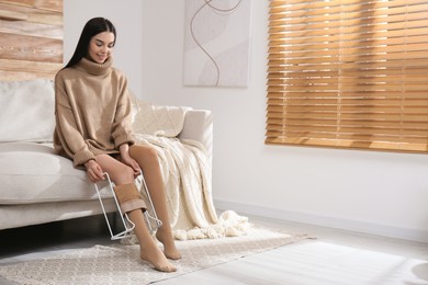 Photo of Woman wearing compression tights with donner in living room. Space for text
