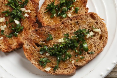 Photo of Tasty bruschettas with oil and garlic on plate, top view