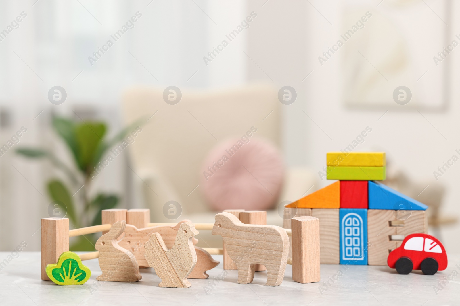 Photo of Set of wooden toys on light grey table indoors. Children's development