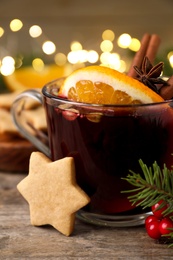 Photo of Aromatic mulled wine on wooden table, closeup
