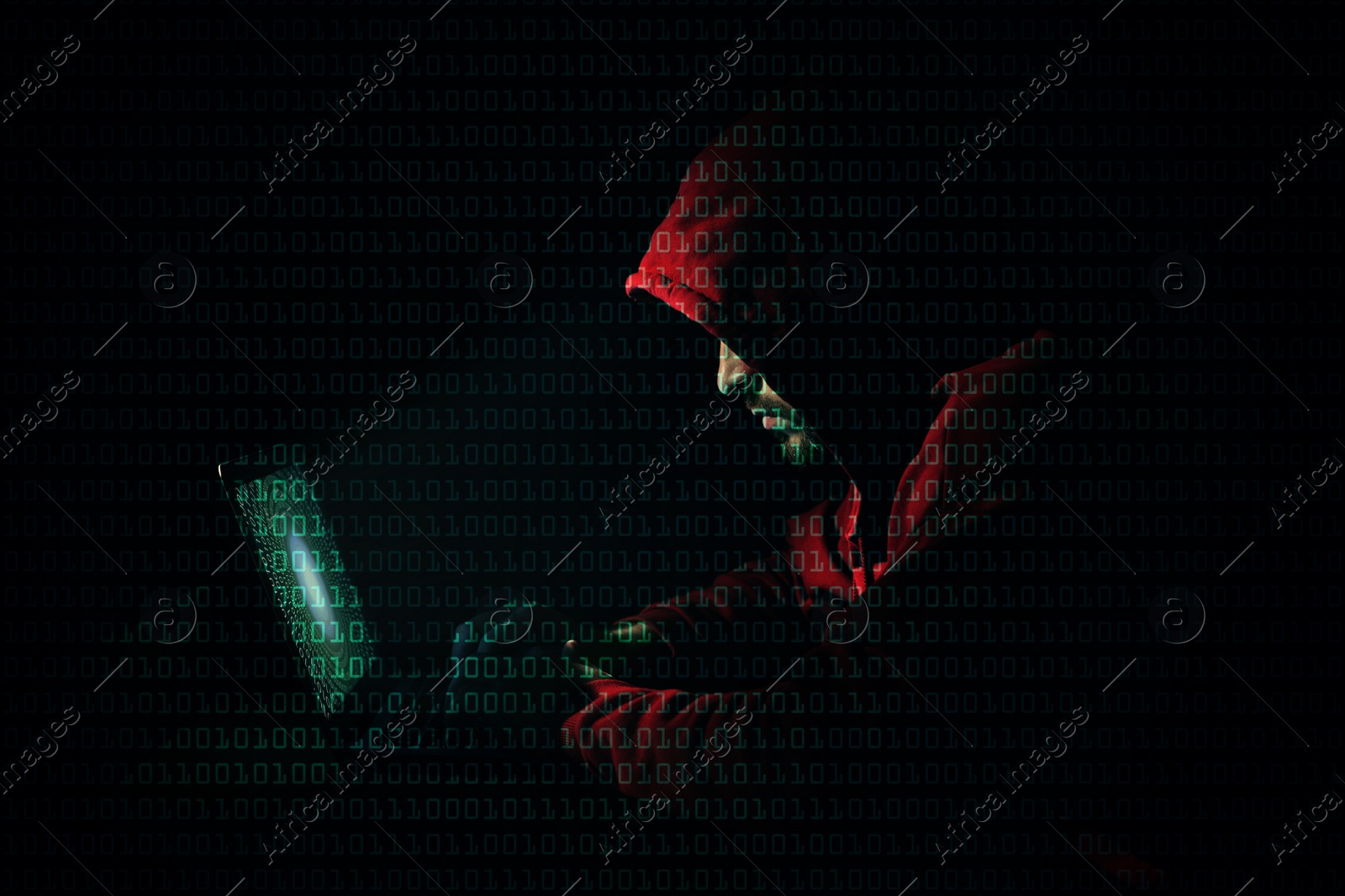 Image of Anonymous man with laptop and binary code in darkness