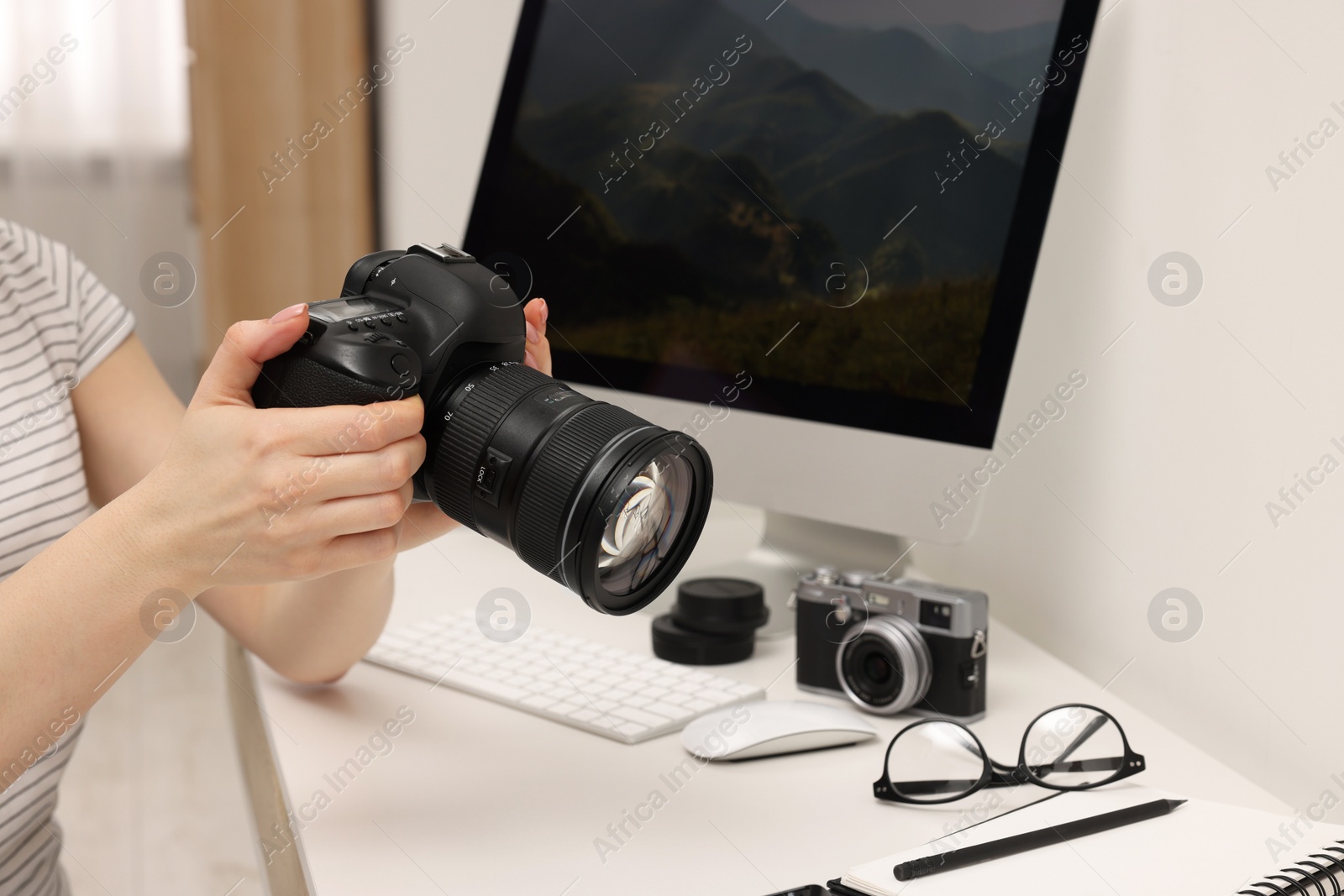 Photo of Photographer with camera at white table indoors, closeup