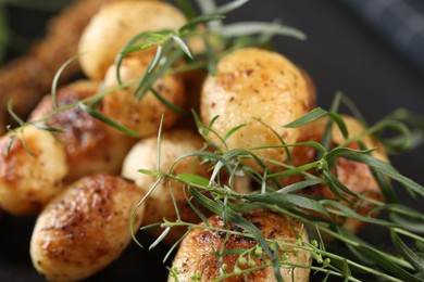 Delicious grilled potatoes with tarragon on table, closeup