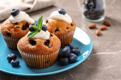 Photo of Platetasty muffins and blueberries on marble table