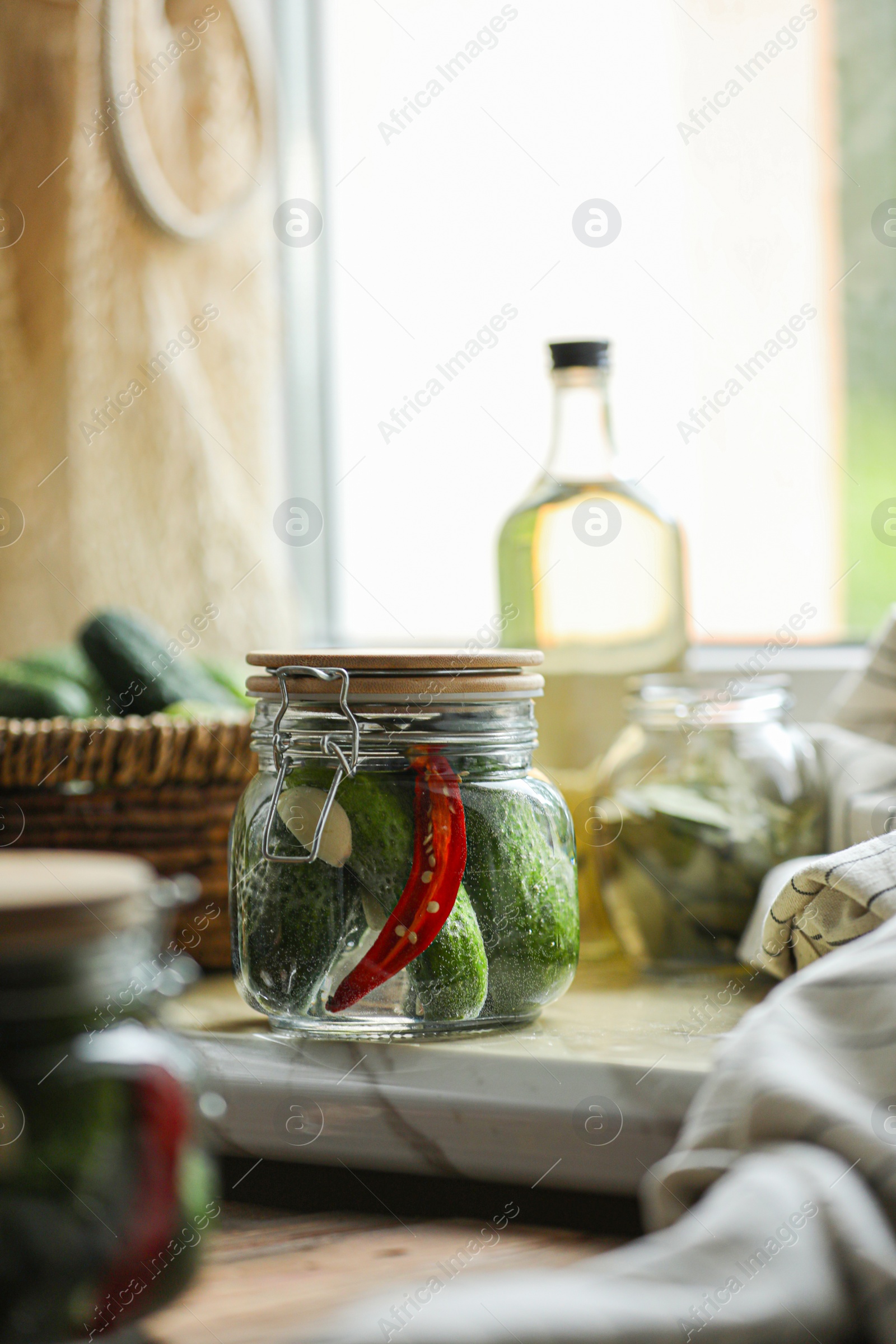 Photo of Jar of pickled cucumbers on wooden table