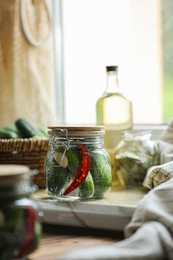 Photo of Jar of pickled cucumbers on wooden table