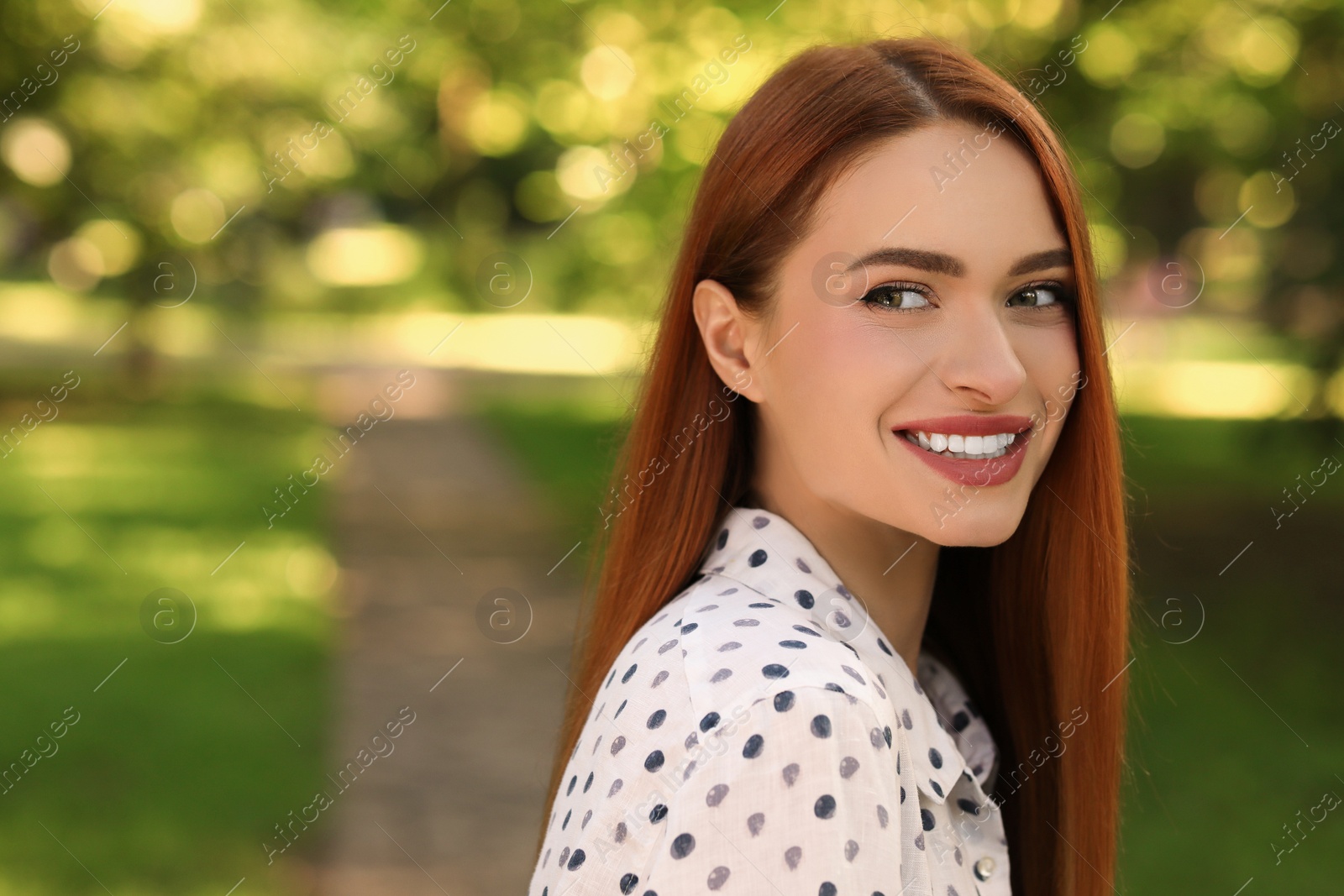 Photo of Portrait of happy young woman outdoors. Space for text. Attractive lady smiling and posing for camera