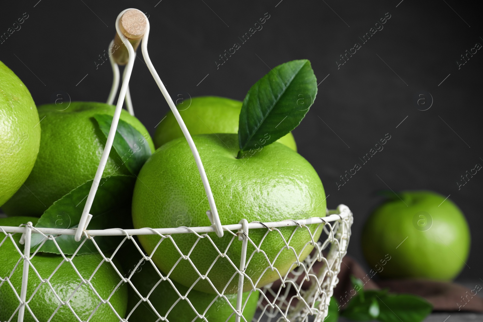 Photo of Fresh ripe sweeties in metal basket, closeup