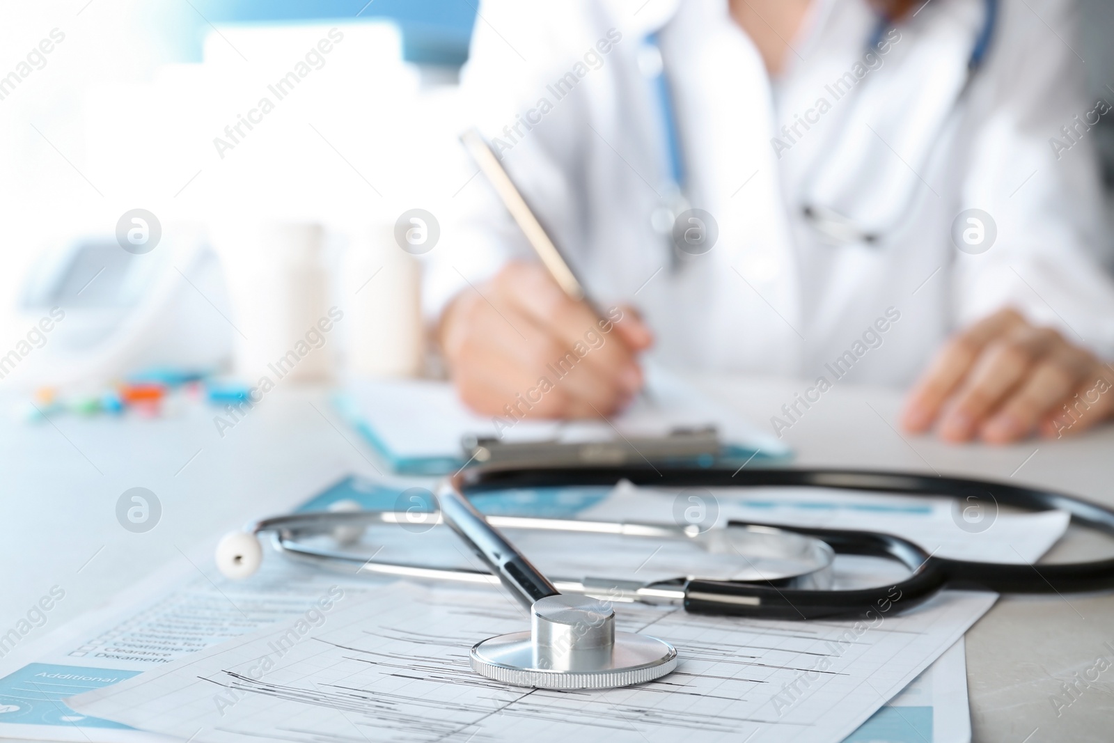 Photo of Stethoscope and blurred doctor on background. Cardiology service