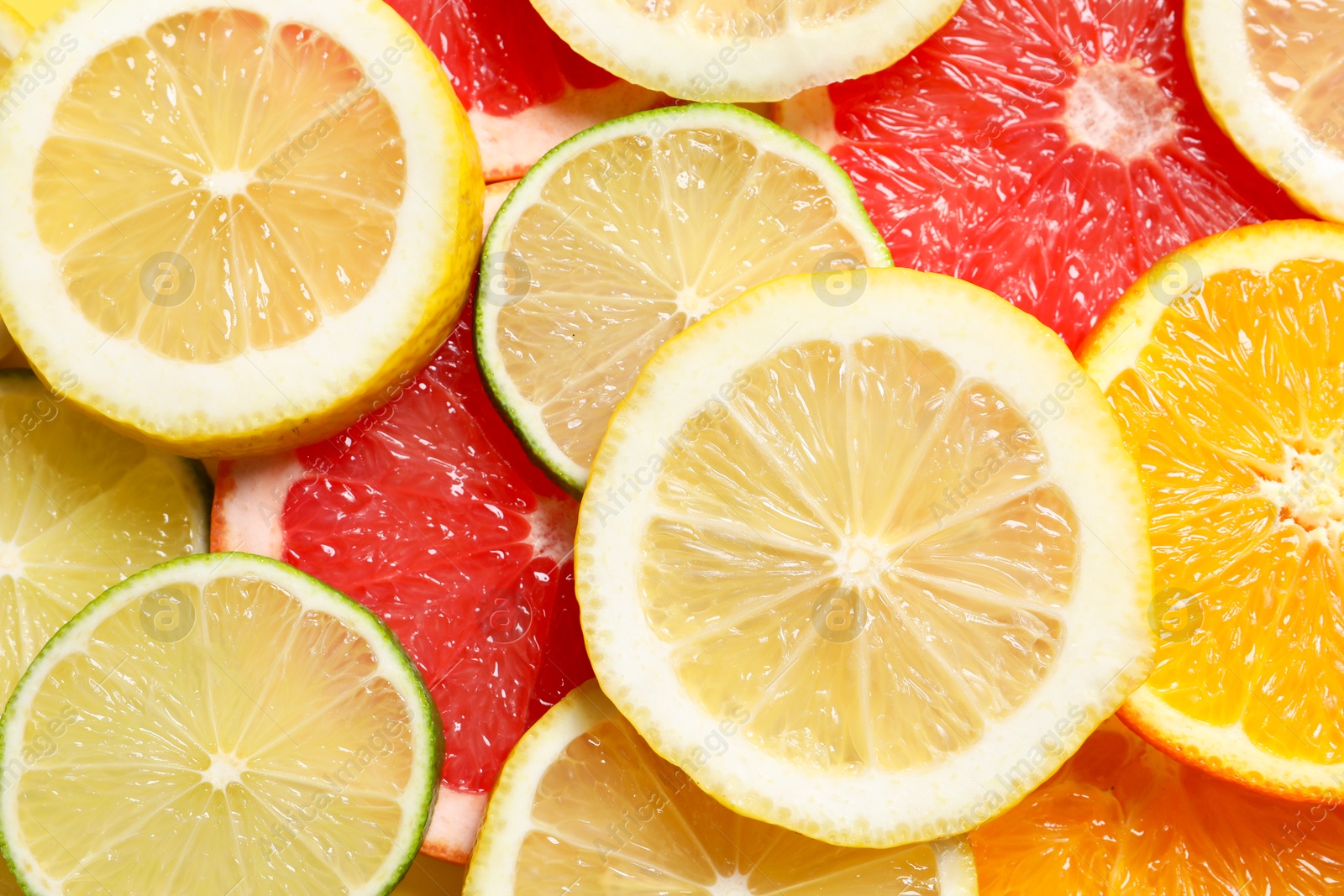 Photo of Different sliced citrus fruits as background, top view