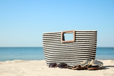 Photo of Stylish beach accessories on sandy sea shore