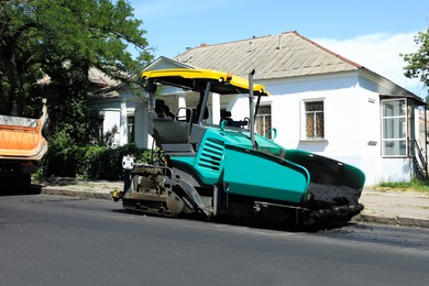 Photo of Asphalt paver working on city street. Road repair