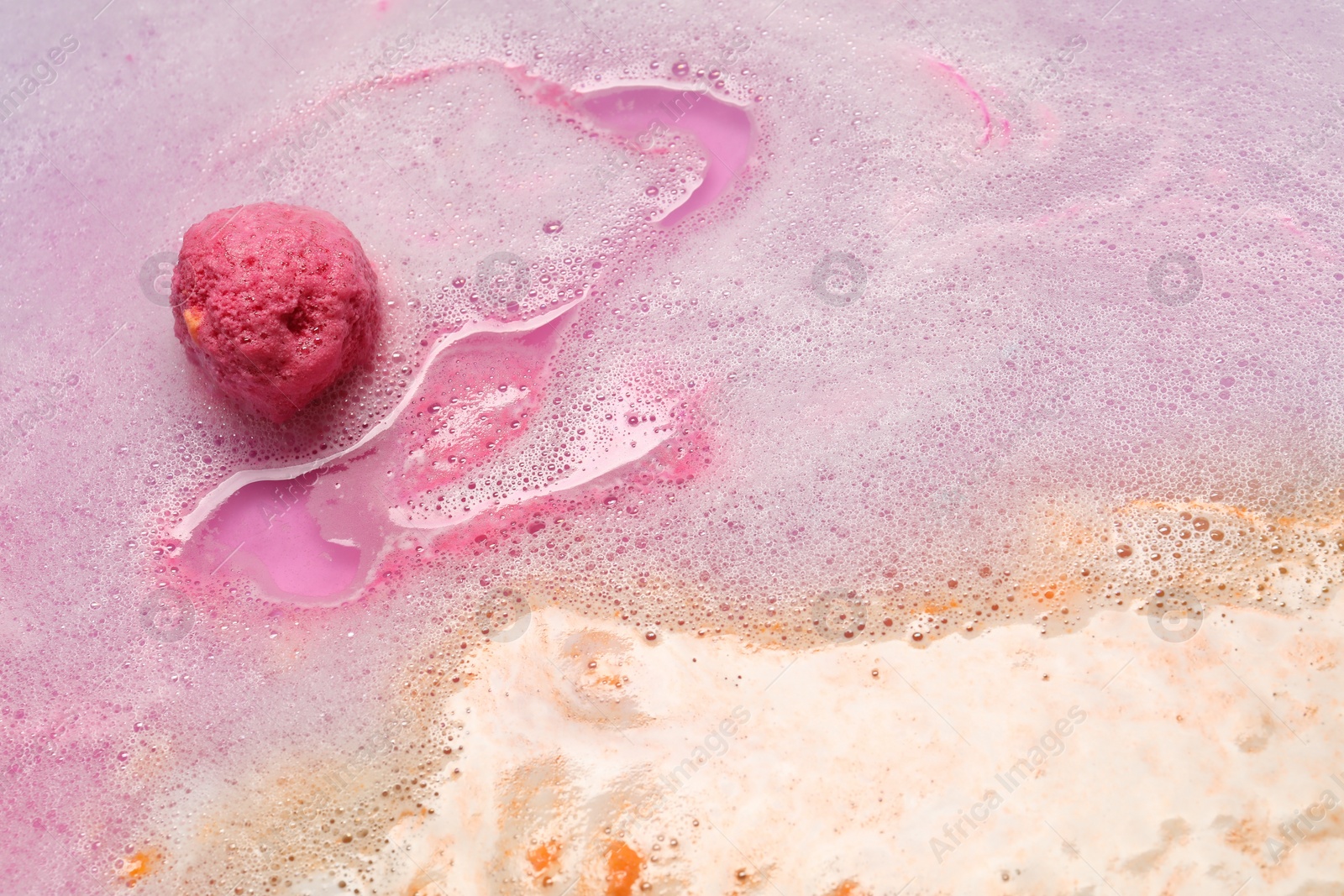 Photo of Beautiful pink bath bomb dissolving in water