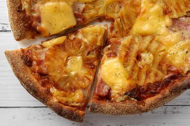 Photo of Delicious Hawaiian pizza with pineapple on white wooden table, top view
