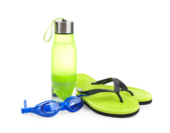 Photo of Swimming goggles, water bottle and flip flops isolated on white