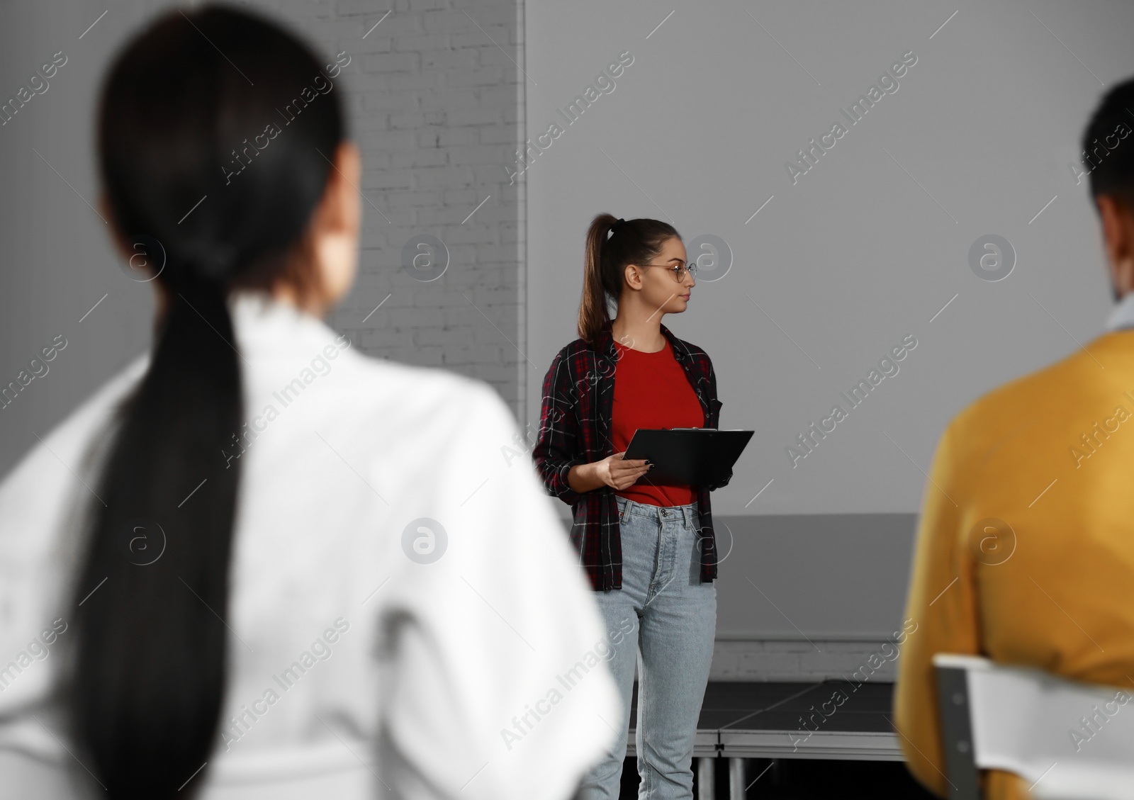 Photo of Female business trainer giving lecture in conference room with projection screen