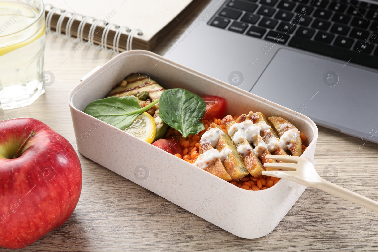 Photo of Healthy products high in vegetable fats near laptop on wooden table, closeup