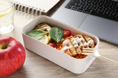 Healthy products high in vegetable fats near laptop on wooden table, closeup