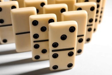 Photo of Many domino tiles on white background, closeup