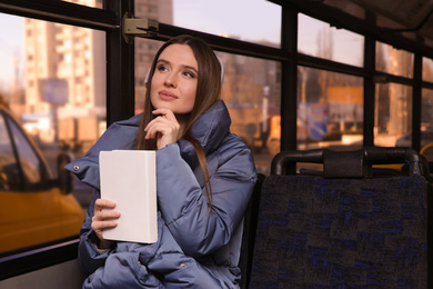 Woman listening to audiobook in trolley bus