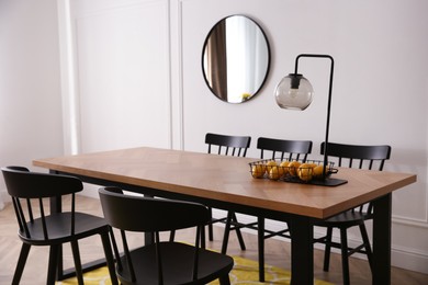 Photo of Stylish wooden dining table and chairs in room. Interior design