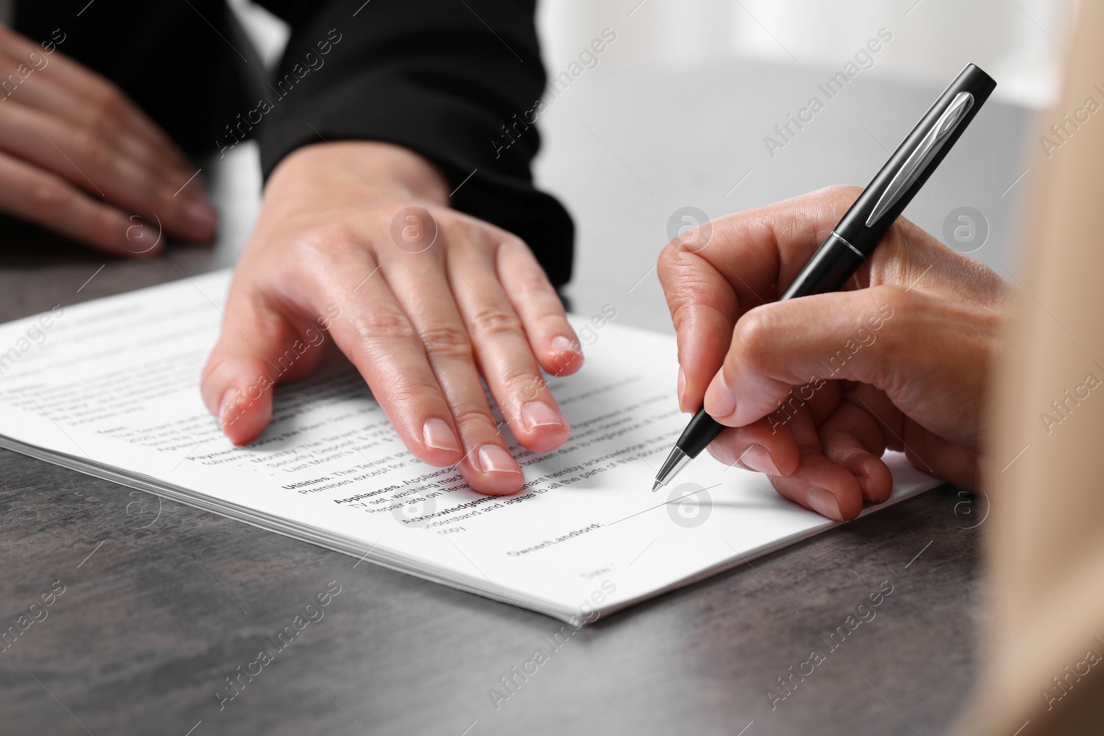 Photo of Manager showing client where she must to mark signature at dark table, closeup