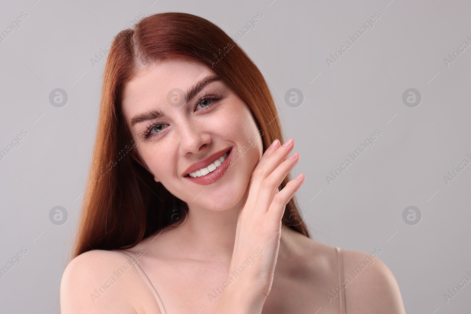 Photo of Portrait of smiling woman on grey background, closeup