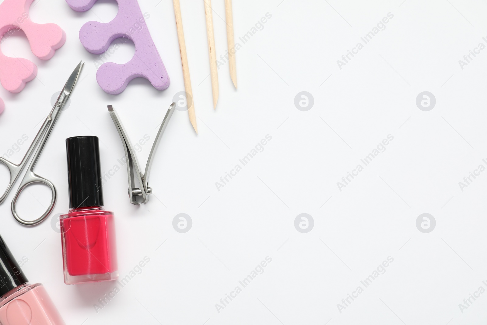 Photo of Nail polishes and set of pedicure tools on white background, flat lay. Space for text