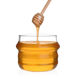 Honey dripping from wooden dipper into jar isolated on white