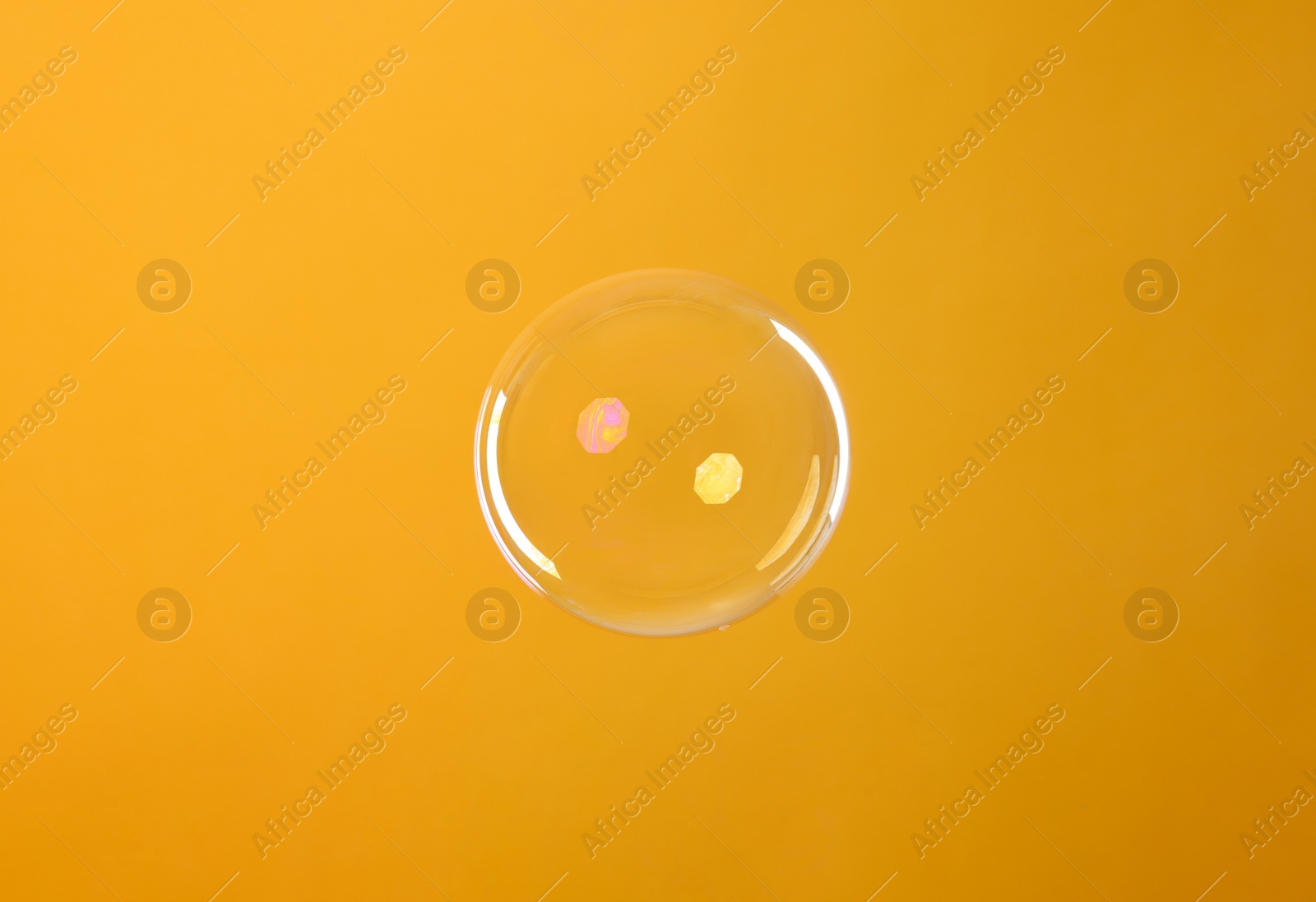 Photo of One beautiful soap bubble on orange background