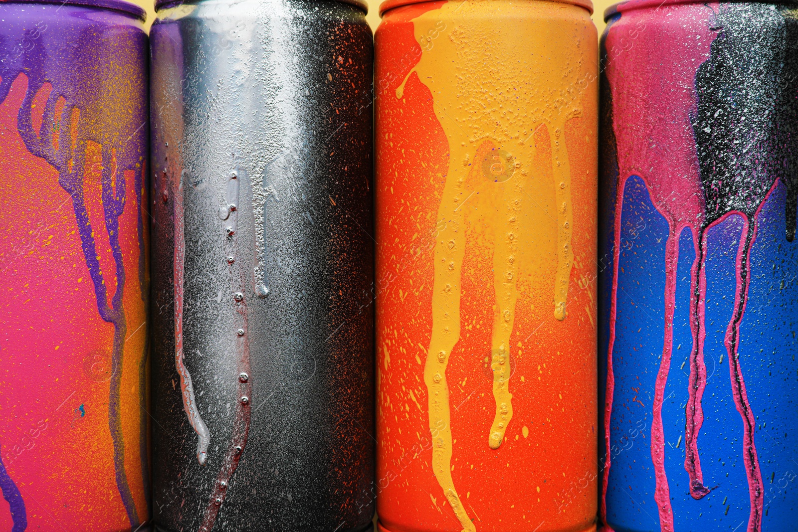 Photo of Used cans of spray paints as background, top view. Graffiti supplies