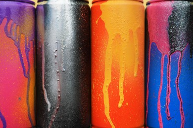 Used cans of spray paints as background, top view. Graffiti supplies
