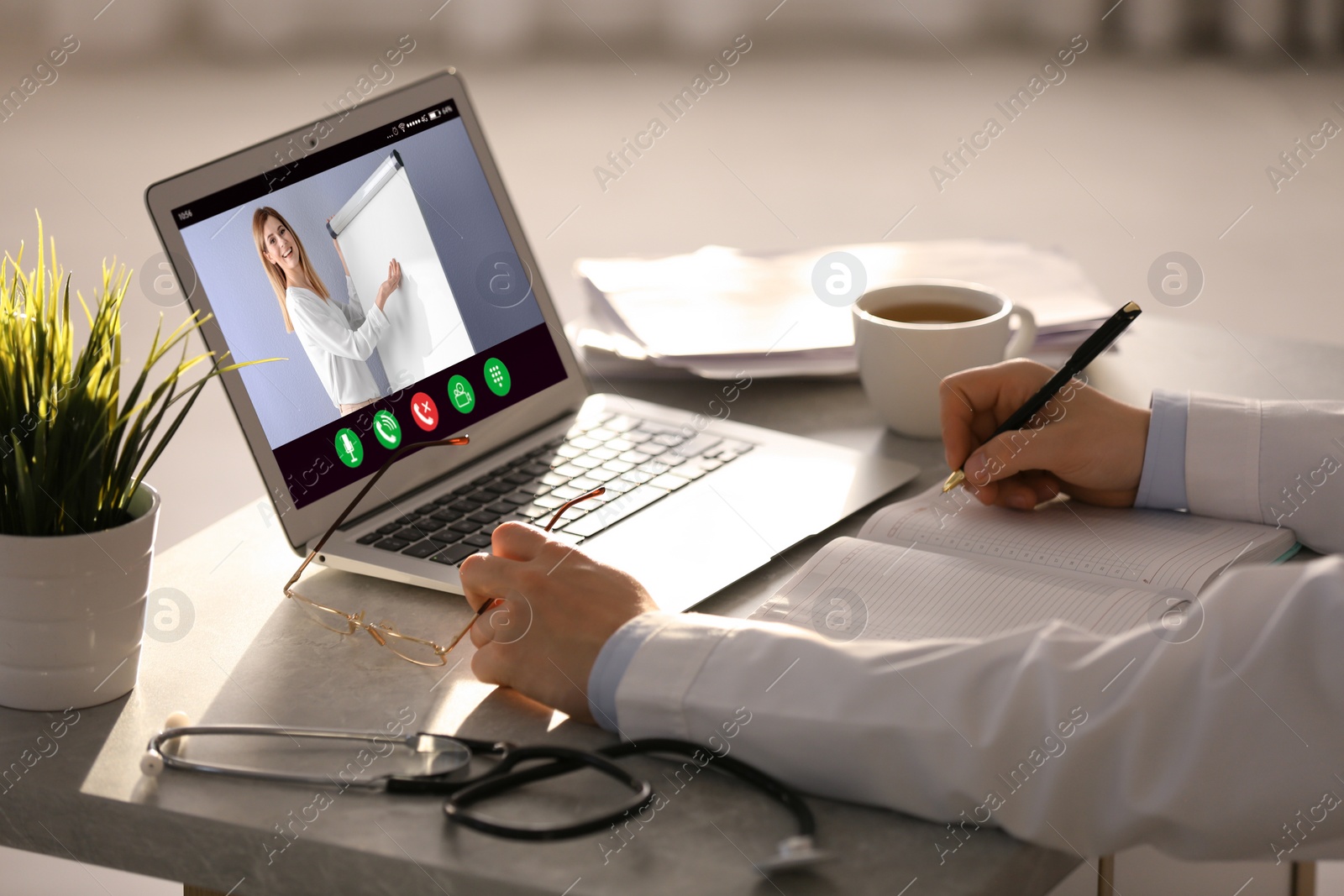 Image of Doctor having online video consultation with business trainer at table, closeup