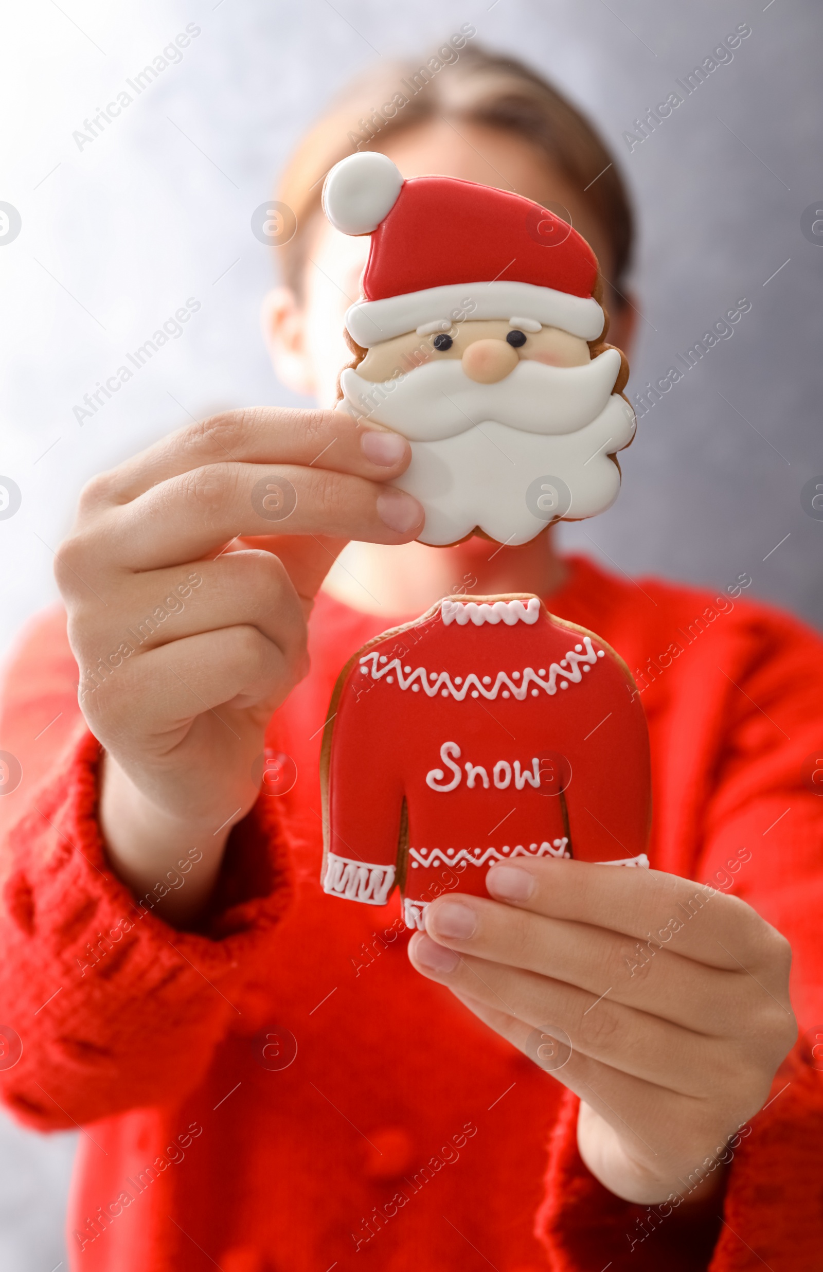 Photo of Woman holding delicious homemade Christmas cookies on grey background, closeup